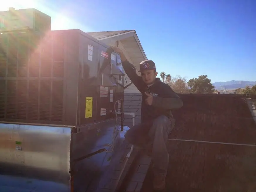 HVAC technician performing HVAC Inspection on a rooftop unit in Southside
